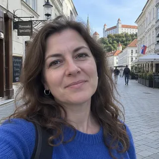 Portrét Lujzy Bednárikovej, ženy okolo štyridsiatky s vlnitými hnedými vlasmi v modrom svetri