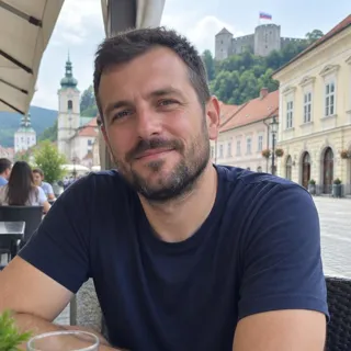 Portret Rajka Verbiča, moškega v poznih tridesetih s kratko brado v temno modri majici